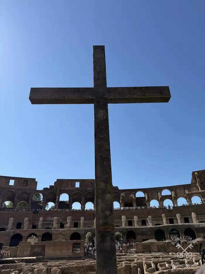 A cruz no eixo da arena, com terra de Jerusalém na base.